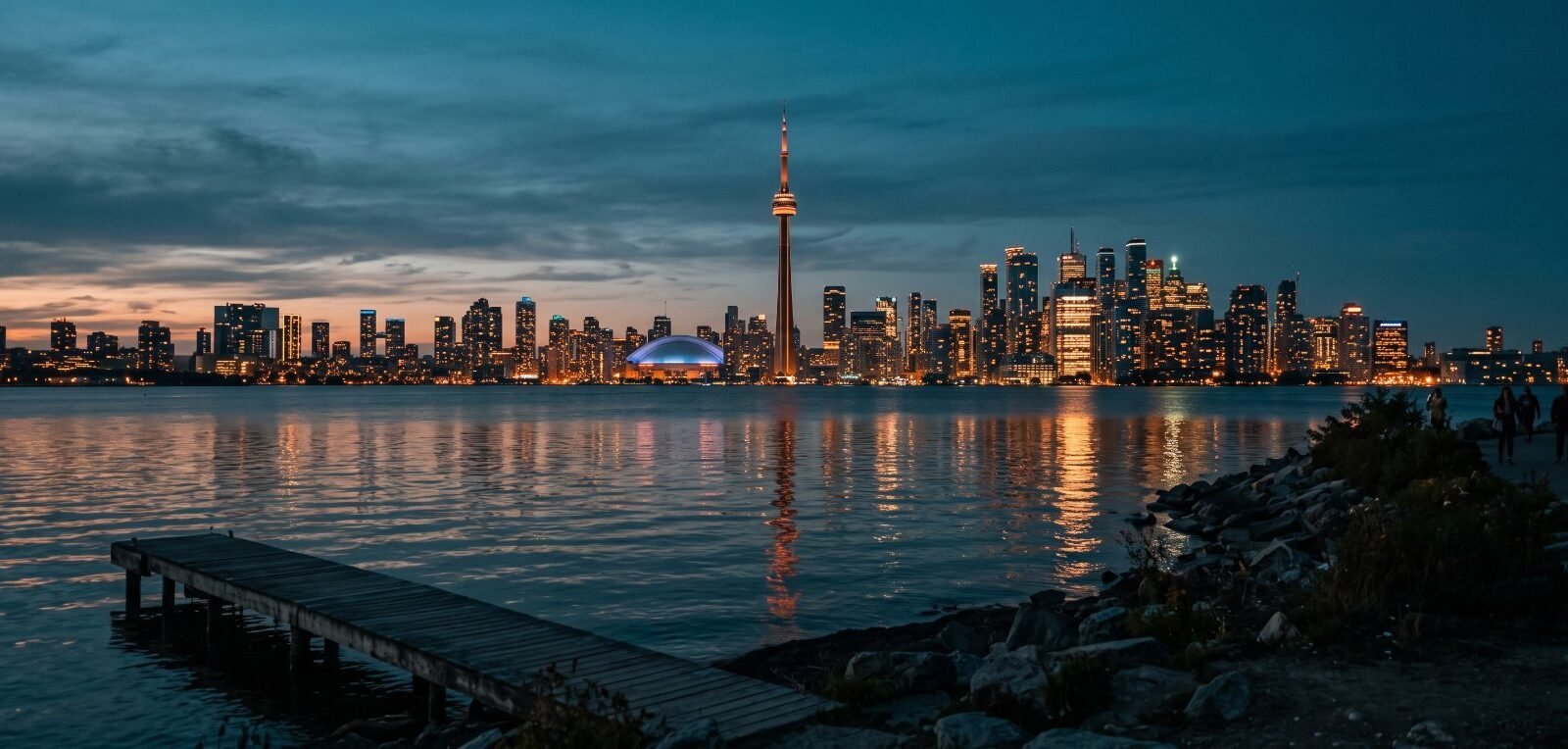 The Toronto skyline and CN Tower at dusk across Lake Ontario