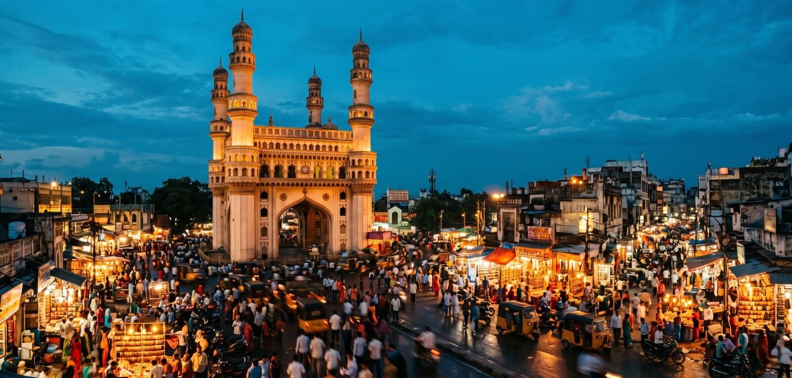 The Charminar in Hyderabad at dusk above a crowded, lit street market